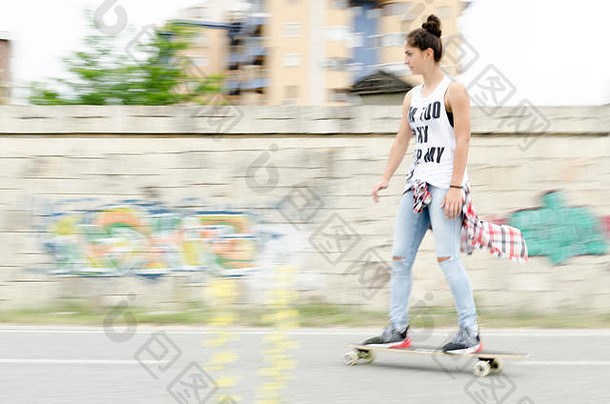 美丽的年轻的女人开车滑板
