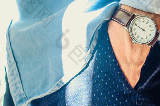 关闭男人的附件优雅的手腕手表手口袋里滚衬衫袖子非正式的休闲穿概念