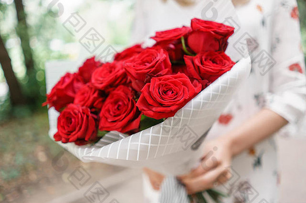 美丽的花束年轻的女孩持有花安排红色的玫瑰概念花商店内容目录