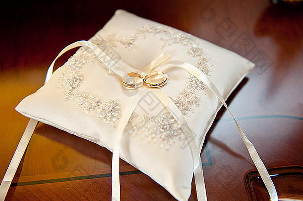 令人惊异的金闪亮的环珠宝婚礼仪式铺设白色美丽的枕头弓