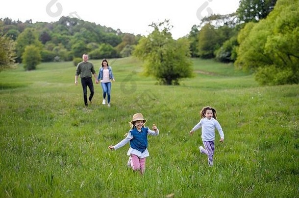 快乐家庭小女儿运行在户外春天自然