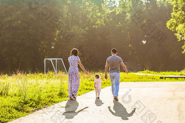 快乐家庭户外活动后视图父母婴儿女儿有趣的走夏天公园