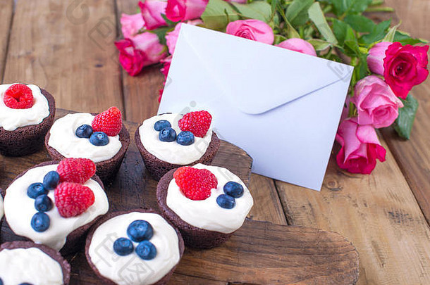 巧克力松饼树莓蓝莓白色奶酪奶油棕色（的）木董事会花束新鲜的粉红色的玫瑰情人自制的糕点早餐免费的空间文本