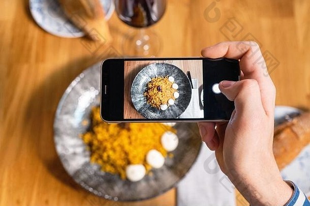 男人。手智能手机拍摄食物餐厅咖啡馆高质量照片