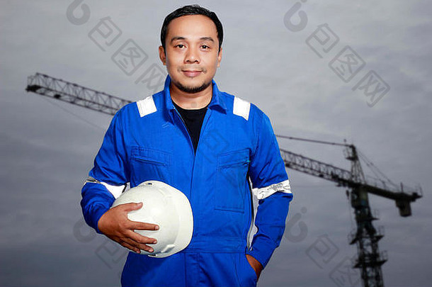 肖像亚洲男人。工程师承包商起重机背景