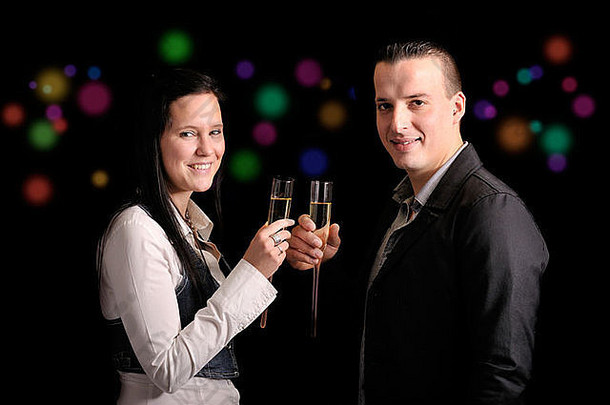 年轻的接吻夫妇玻璃香槟黑色的背景