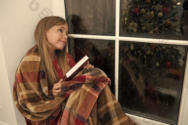 可爱的做梦的人小孩子读书圣诞节夏娃小读者包装格子坐窗口窗台上儿童图片书魔法圣诞节精神小女孩享受阅读圣诞节故事