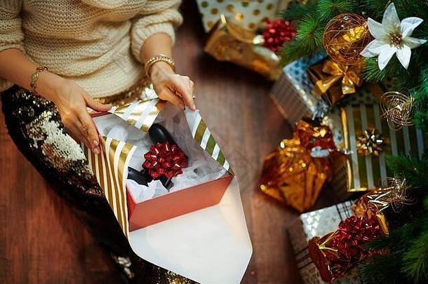 特写镜头时尚的女人黄金金片裙子白色毛衣装饰圣诞节树现在盒子包装圣诞节礼物操纵杆