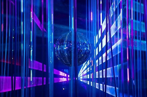 跳舞地板上迪斯科晚上镜子球象征有趣的聚会，派对夜总会跳舞俱乐部发光的阶段灯反射蓝色的