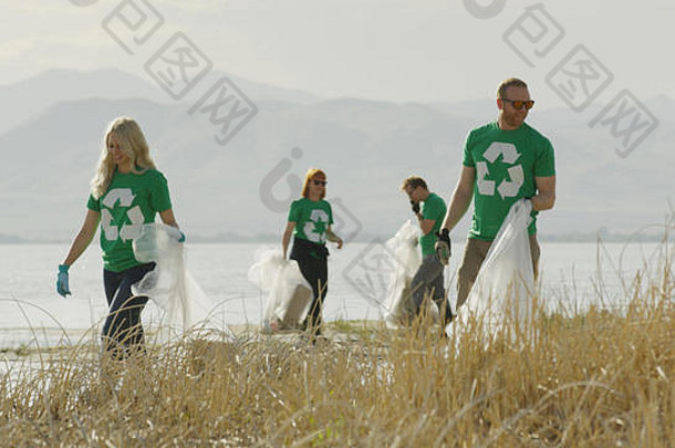 志愿者收集回收垃圾垃圾远程长满草的湖海岸