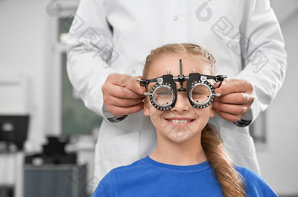 眼科医生白色外套特殊的医疗设备健康眼睛检查视力微笑女孩坐着相机测试眼镜