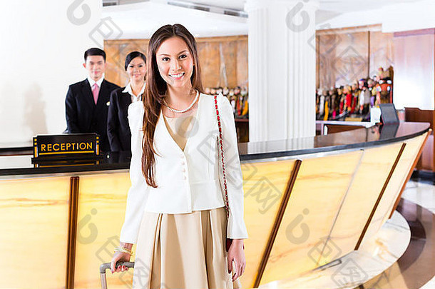 亚洲中国人女人到达前面桌子上奢侈品酒店业务衣服电车