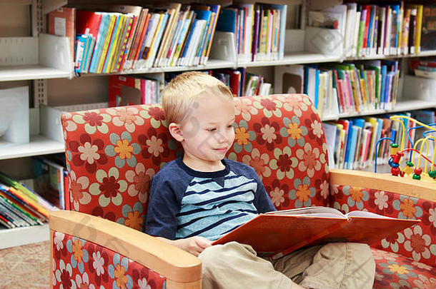 年轻的孩子阅读书坐着沙发上图书馆