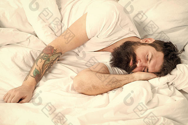 懒惰的早....男人。有胡子的赶时髦的人困了床上早期早....小时失眠睡眠问题放松睡眠概念男人。有胡子的的家伙睡眠白色表健康的睡眠幸福