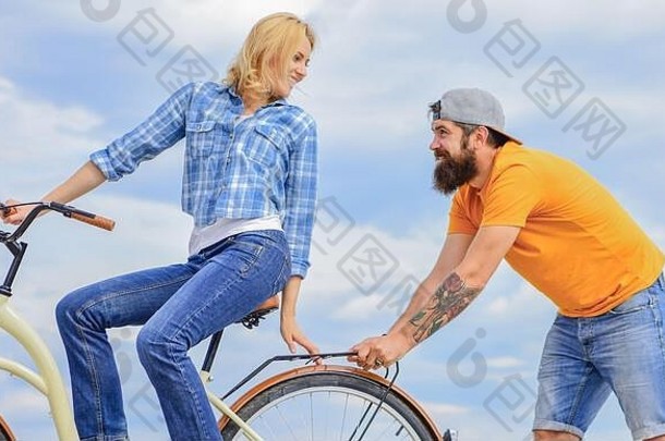 女人游乐设施自行车天空背景服务援助男人。帮助平衡骑自行车女孩骑自行车男人。支持支持帮助支持友谊