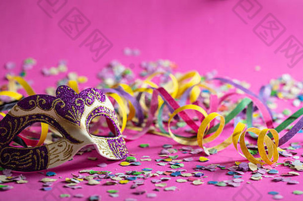 狂欢节聚会，派对紫色的黄金面具飘带五彩纸屑明亮的粉红色的背景横幅