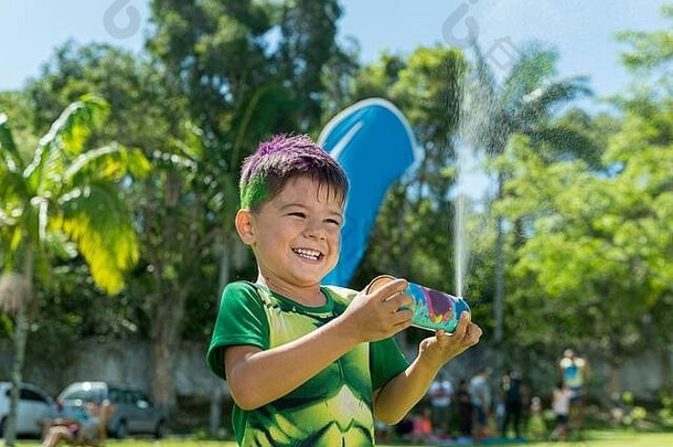 英俊的高加索人男孩绿色紫色的染色头发有趣的泡沫狂欢节在户外美丽的阳光明媚的一天孩子costu