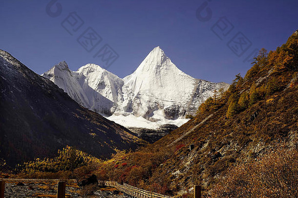 shangri全景视图神圣的被雪所覆盖的山jambeyang黄色的橙色秋天树谷木小径桥雅国家