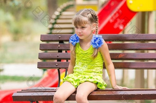 肖像心烦意乱一年女孩坐着板凳上背景操场上