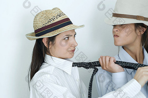 年轻的女朋友穿着按钮衬衫关系帽子拉其他的领带
