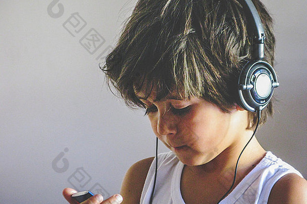 男孩穿耳机听音乐