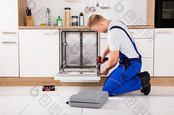 年轻的修理工服务工人修复洗碗机设备厨房