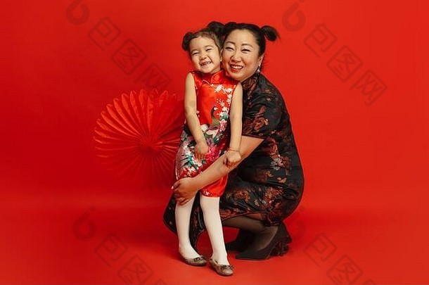 拥抱微笑快乐快乐中国人一年亚洲妈妈。女儿肖像孤立的红色的背景传统的服装庆祝活动人类情绪假期Copyspace