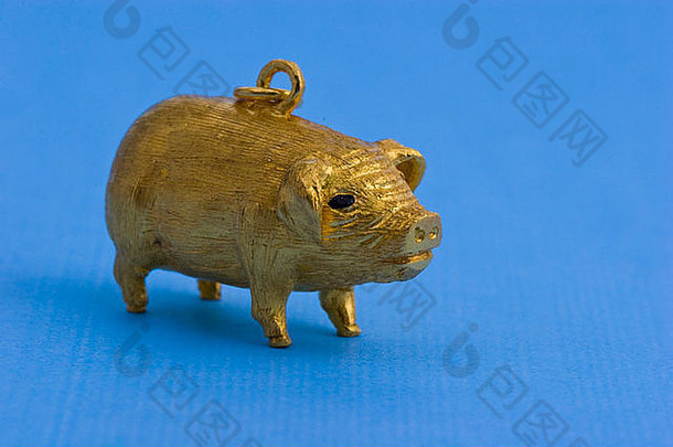 黄金猪小雕像蓝色的背景