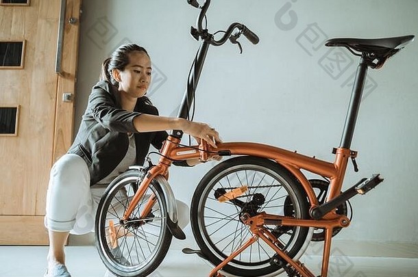 年轻的企业家女人准备折叠自行车首页