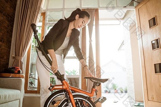亚洲年轻的女人站生活房间开放褶皱折叠自行车