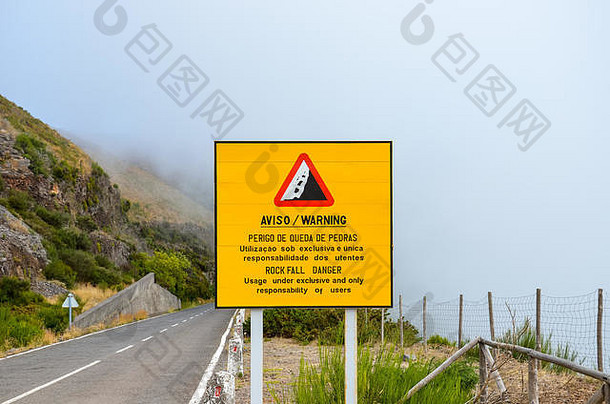 黄色的信息标志警告落石危险葡萄牙语英语语言使用路独家责任用户有雾的景观背景