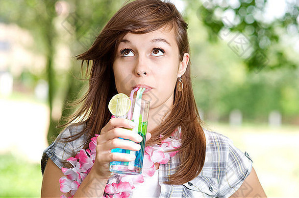 年轻的女人喝蓝色的库拉索岛鸡尾酒debica波兰