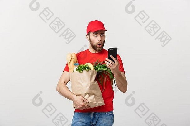 交付概念英俊的高加索人杂货店交付快递男人。红色的统一的杂货店盒子新鲜的水果蔬菜