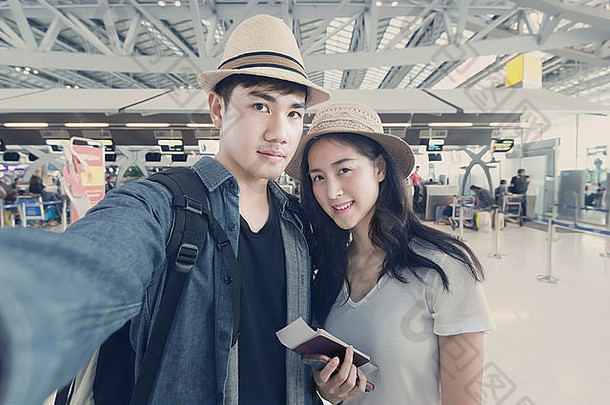 亚洲夫妇旅游采取自拍机场旅程
