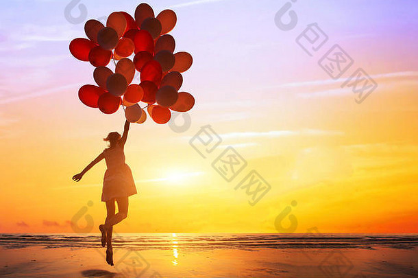 幸福梦想概念轮廓快乐女人跳五彩缤纷的气球日落海滩