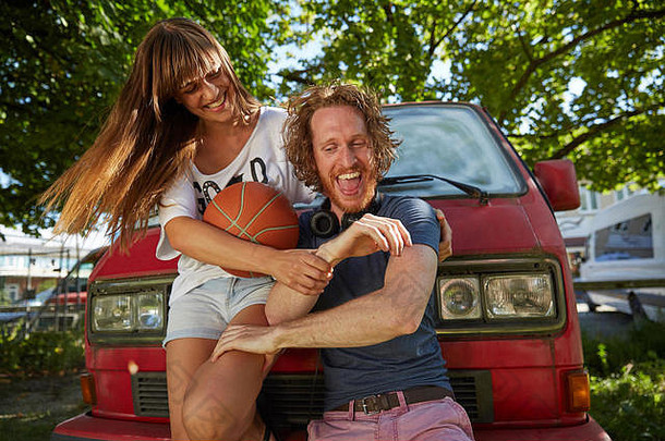年轻的夫妇愚弄在户外笑年轻的女人持有<strong>篮球</strong>