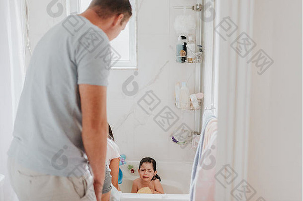 父母在洗澡时带着哭泣的女儿