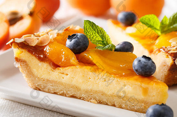 美丽的甜点芝士蛋糕杏子蓝莓杏仁特写镜头板水平
