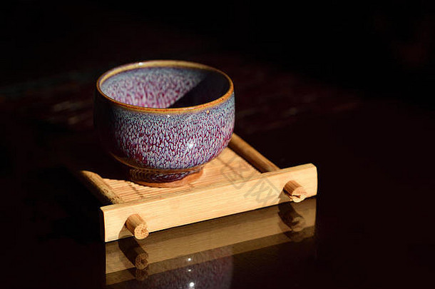 特写镜头陶瓷空陶瓷茶杯小竹子董事会黑暗背景中国人茶仪式