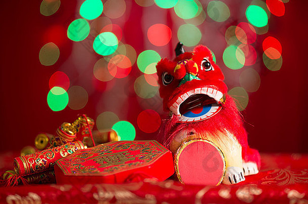 中国人一年节日装饰微型跳舞狮子鞭炮红色的闪闪发光的背景