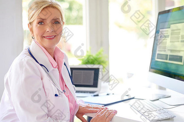 微笑高级女研究医生电脑移动PC工作桌子上