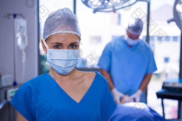 肖像女护士穿外科手术面具操作剧院