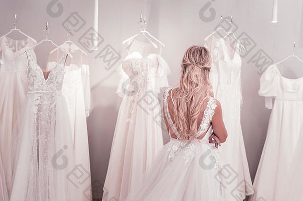 美丽的金发女郎女人站前面婚礼礼服