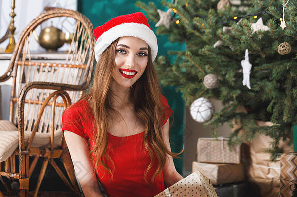 兴奋圣诞节女人穿圣诞老人他红色的衣服坐着微笑一年云杉一年圣诞节假期记忆礼物购物折扣商店雪少女圣诞老人老人化妆发型狂欢节