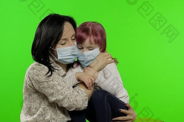 生病的妈妈。拥抱女儿医疗面具冠状病毒概念年轻的家庭检疫病毒疾病疾病疫情伤心女人拥抱孩子浓度关键绿色屏幕
