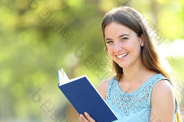 快乐女人相机持有空白纸书绿色背景公园