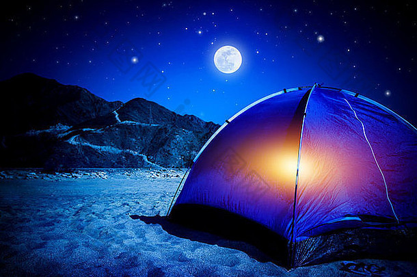 营桑迪海滩帐篷晚上光内部月亮光活跃的旅游徒步旅行旅行概念