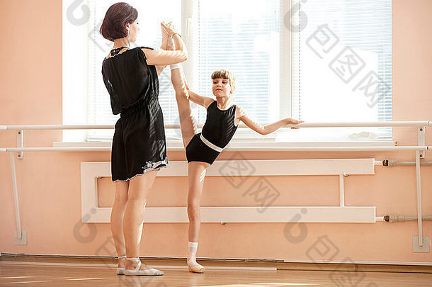 芭蕾舞老师调整腿位置年轻的芭蕾舞 演员巴利