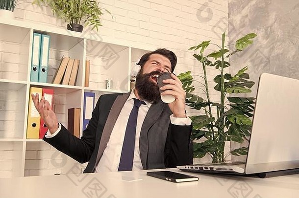 现代生活经理唱卡拉ok咖啡杯有胡子的男人。享受现代音乐玩耳机商人放松现代办公室现代技术业务快乐