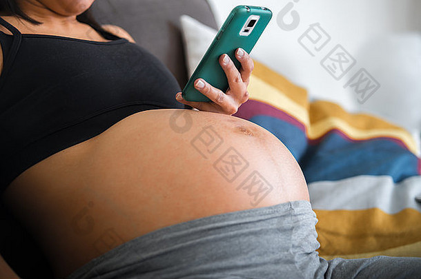 婴儿撞图像月怀孕了女人持有移动电话